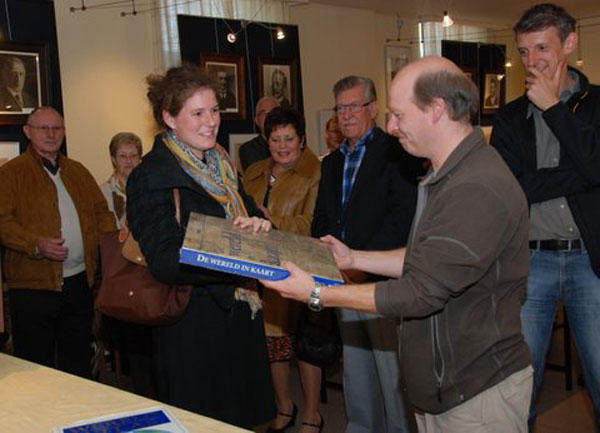 Johanna Heuylebroeck, directrice van KBC-Bazel overhandigt de eerste prijs De Wereld in Kaart, aan Daniël Sterckx, de echtgenoot van winnares Veerle Heyman.