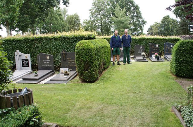 Verantwoordelijk van de Beverse begraafplaats Harry Andoorn en assistent Jef tussen een reeds ingezaaid wandelpad.